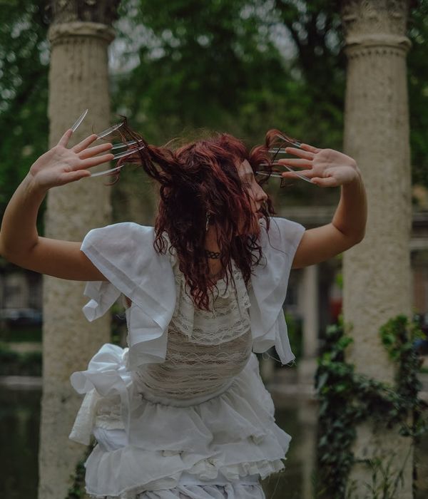 Woman performing a gentle, flowing movement in a calm setting.